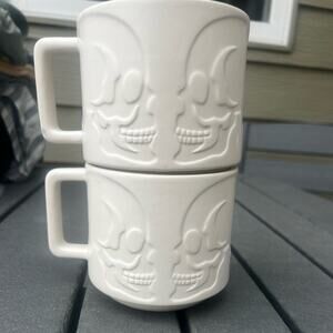 Pair of mugs, (2) ceramic skull relief design, cream